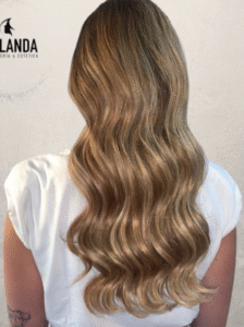 Peinado de melena larga con ondas suaves y reflejos dorados, realizado por Peluquería & Estética Yolanda en Toledo.